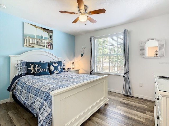 bedroom featuring ceiling fan, wood finished floors, and baseboards