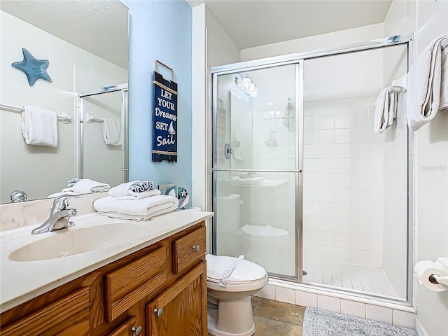 bathroom featuring toilet, tile patterned flooring, vanity, and a shower stall