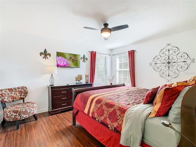 bedroom featuring baseboards, a ceiling fan, and dark wood-style flooring