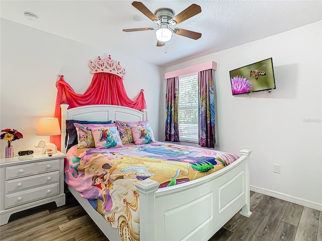 bedroom featuring a ceiling fan, baseboards, and wood finished floors