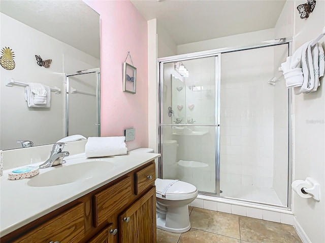 full bath featuring a stall shower, tile patterned flooring, vanity, and toilet