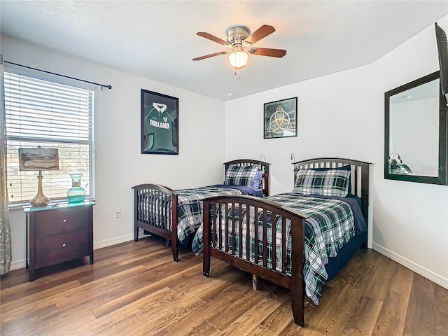 bedroom with wood finished floors, a ceiling fan, and baseboards