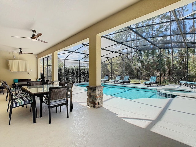 view of swimming pool with ceiling fan, a patio, outdoor dining space, and glass enclosure