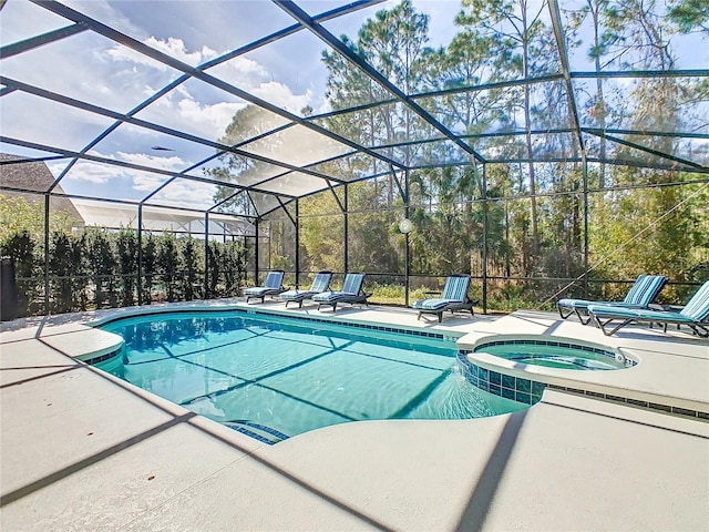 view of pool featuring glass enclosure, a pool with connected hot tub, and a patio