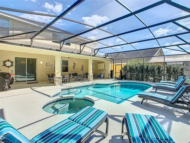 view of pool featuring glass enclosure, a pool with connected hot tub, a grill, and a patio