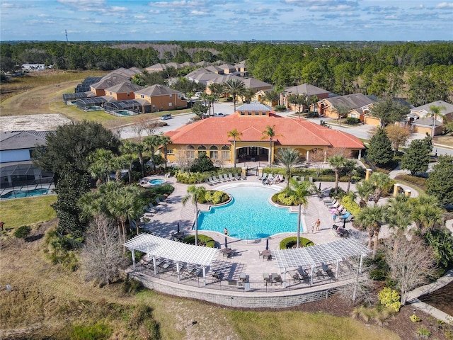 view of swimming pool featuring a patio and a wooded view