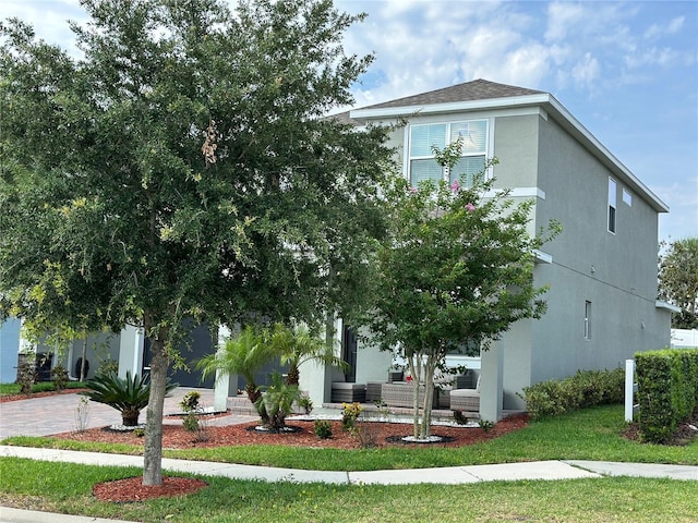 obstructed view of property featuring roof with shingles, decorative driveway, and stucco siding