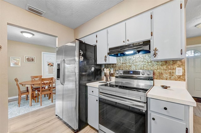 kitchen featuring stainless steel appliances, light countertops, visible vents, and under cabinet range hood