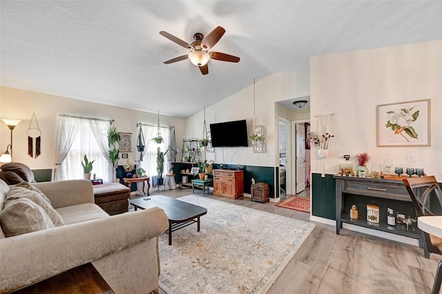 living room featuring vaulted ceiling, ceiling fan, and wood finished floors