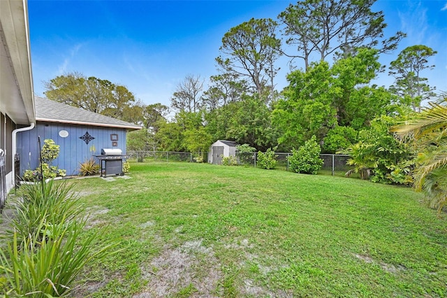 view of yard featuring an outbuilding, a fenced backyard, and a storage unit