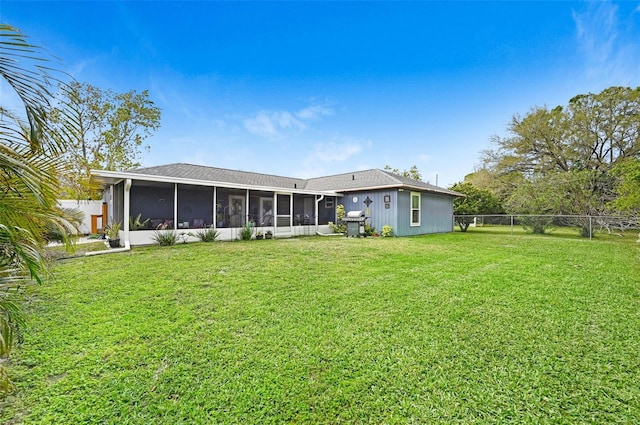 rear view of property featuring a sunroom, a fenced backyard, and a yard