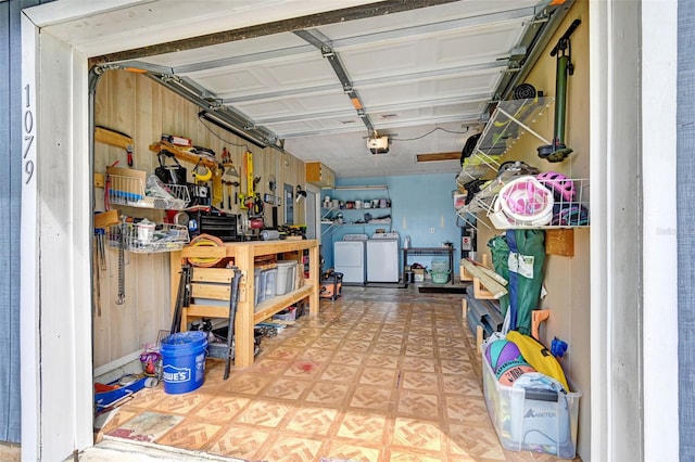 garage featuring a garage door opener, washing machine and dryer, and a workshop area