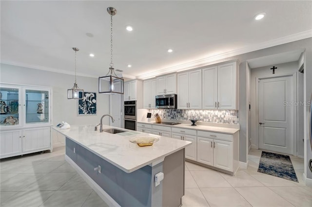 kitchen with tasteful backsplash, a center island with sink, appliances with stainless steel finishes, crown molding, and a sink