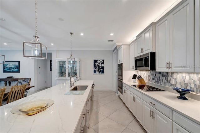 kitchen featuring a sink, ornamental molding, appliances with stainless steel finishes, decorative backsplash, and decorative light fixtures