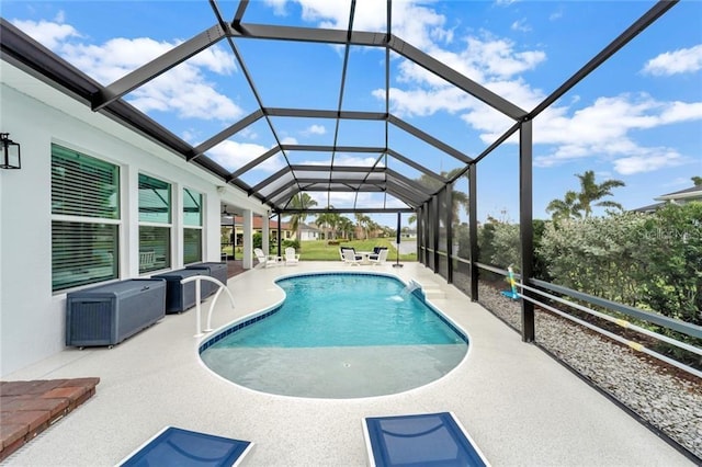 outdoor pool with glass enclosure and a patio