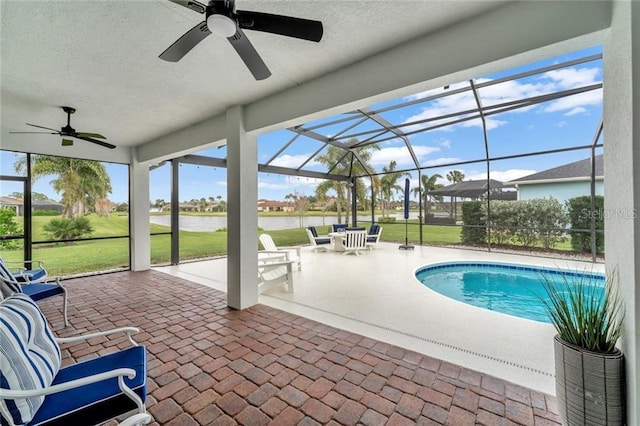 outdoor pool featuring glass enclosure, a yard, a patio area, and a ceiling fan