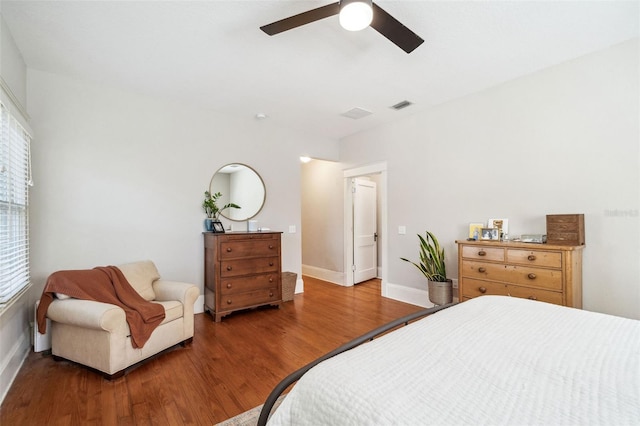 bedroom featuring visible vents, baseboards, a ceiling fan, and wood finished floors