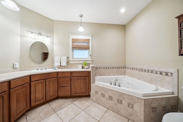 bathroom with tile patterned floors, a tub with jets, and vanity