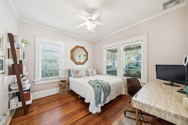 bedroom featuring visible vents, ornamental molding, wood finished floors, baseboards, and ceiling fan