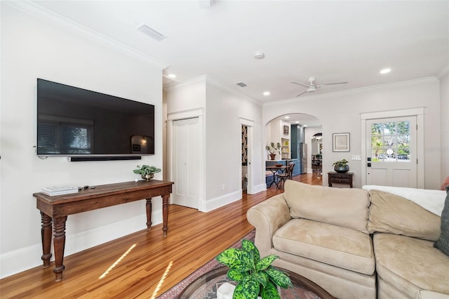 living room with wood finished floors, visible vents, baseboards, recessed lighting, and arched walkways