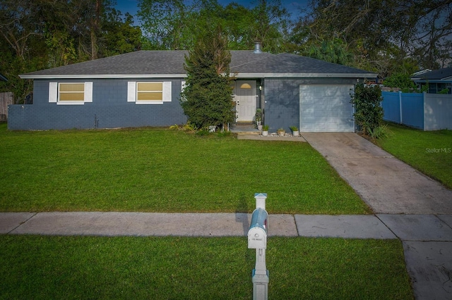 ranch-style home featuring concrete driveway, brick siding, an attached garage, and a front yard