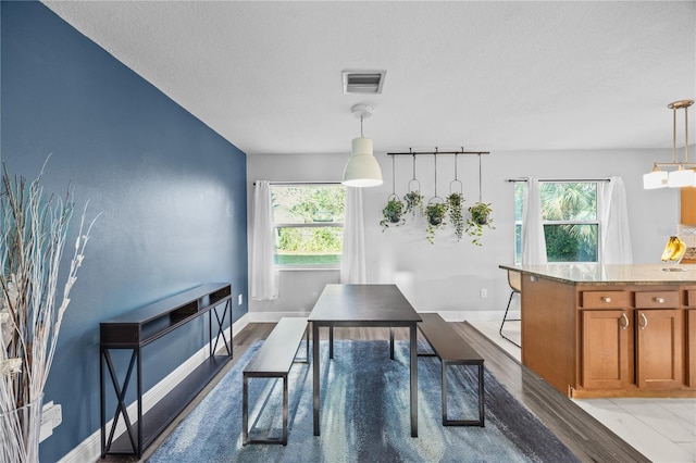 dining space with a healthy amount of sunlight, visible vents, and baseboards