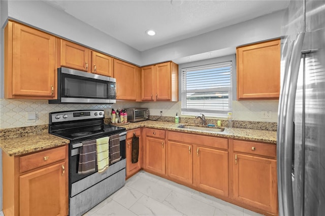 kitchen featuring decorative backsplash, light stone countertops, marble finish floor, stainless steel appliances, and a sink