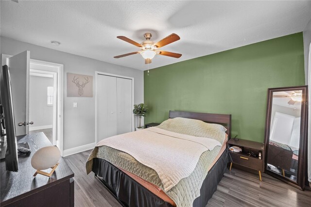 bedroom featuring a textured ceiling, wood finished floors, a ceiling fan, baseboards, and a closet