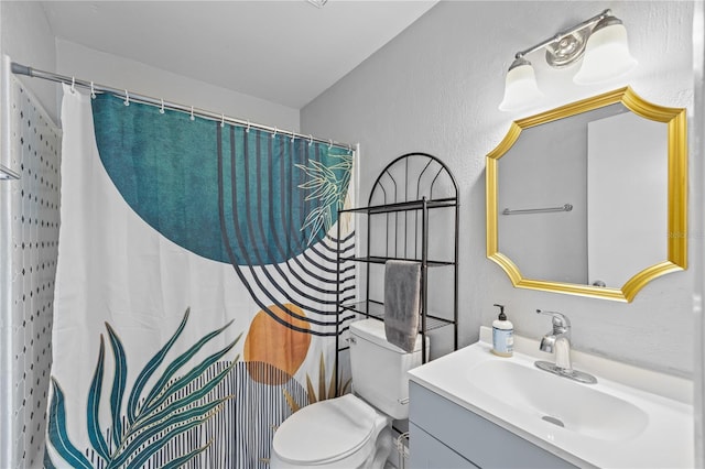 bathroom with toilet, a textured wall, curtained shower, and vanity