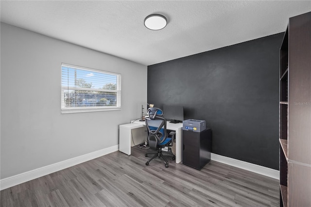 office area featuring a textured ceiling, wood finished floors, and baseboards