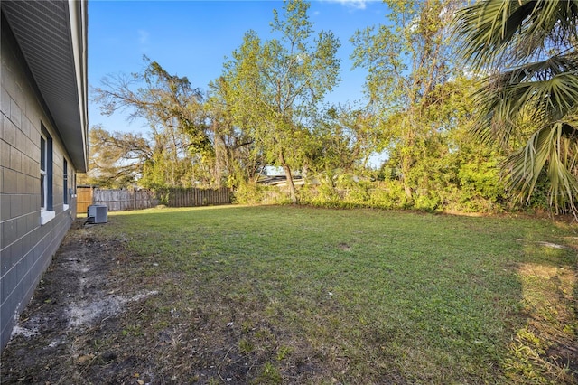 view of yard with fence and central AC