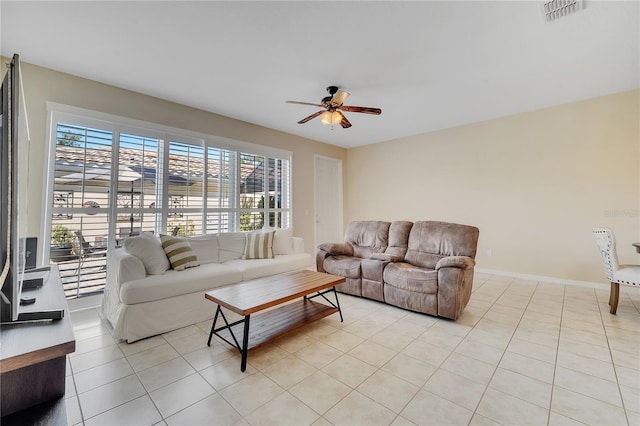 living room featuring a ceiling fan, visible vents, baseboards, and light tile patterned flooring