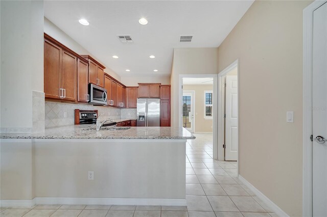 kitchen featuring stainless steel appliances, visible vents, a sink, and decorative backsplash