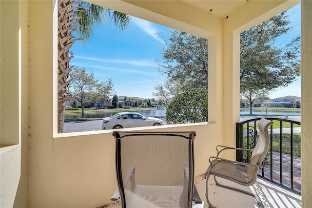 balcony featuring a residential view and a water view