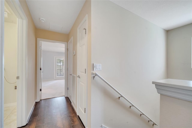 corridor featuring an upstairs landing and baseboards