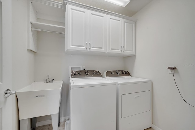 laundry area featuring cabinet space, separate washer and dryer, and a sink