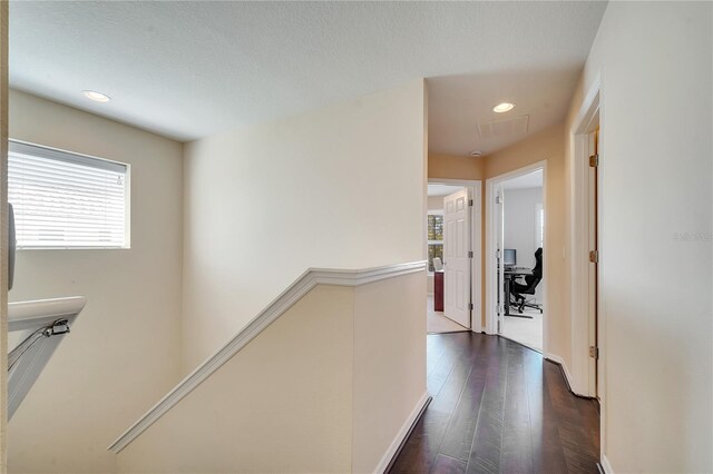 corridor featuring dark wood finished floors, an upstairs landing, and recessed lighting