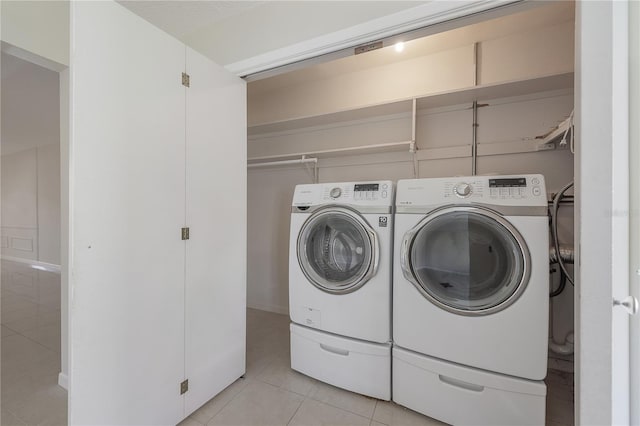 washroom with light tile patterned floors, laundry area, and washer and clothes dryer