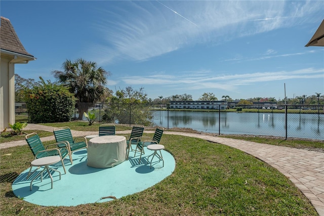 view of patio / terrace featuring a water view and fence