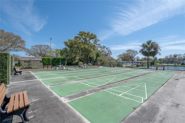 view of property's community featuring fence and shuffleboard