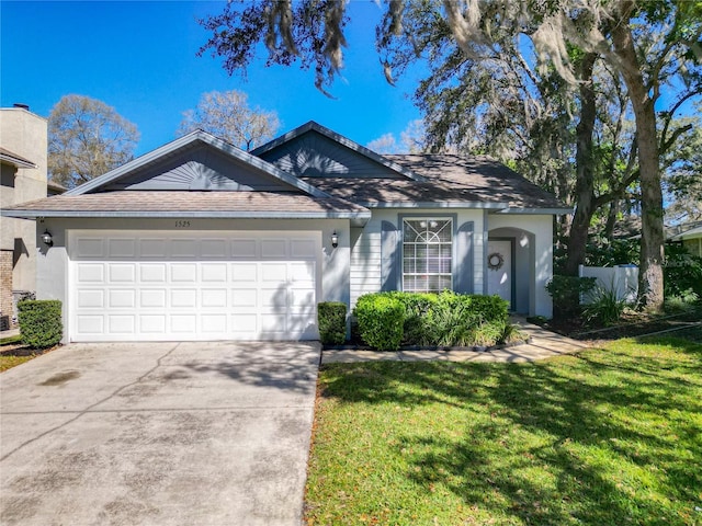 single story home featuring an attached garage, concrete driveway, and a front yard