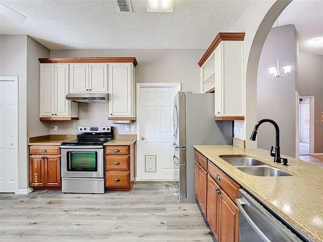 kitchen featuring visible vents, appliances with stainless steel finishes, under cabinet range hood, open shelves, and a sink