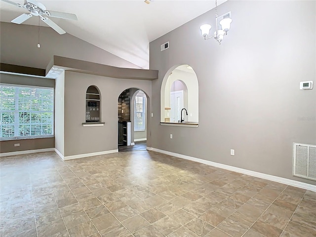 spare room with arched walkways, visible vents, baseboards, and ceiling fan with notable chandelier