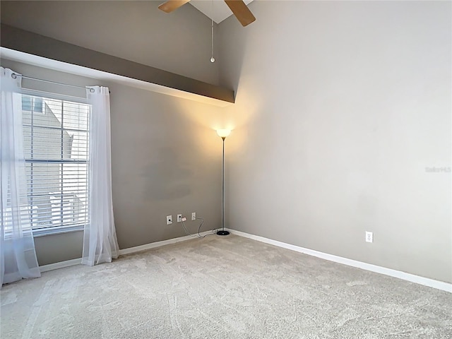 carpeted empty room featuring ceiling fan and baseboards