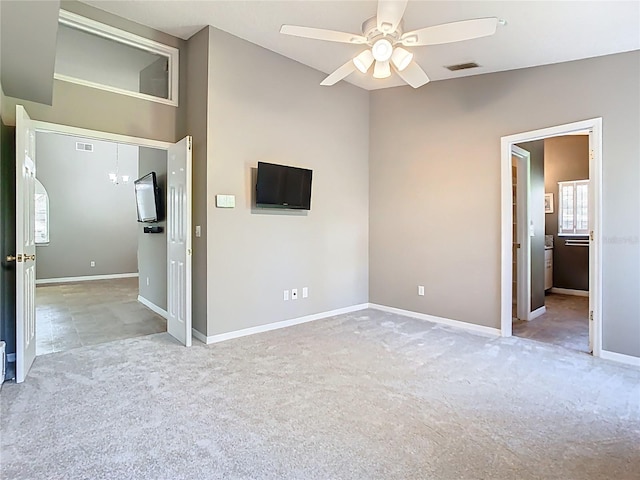 spare room featuring light carpet, ceiling fan, visible vents, and baseboards