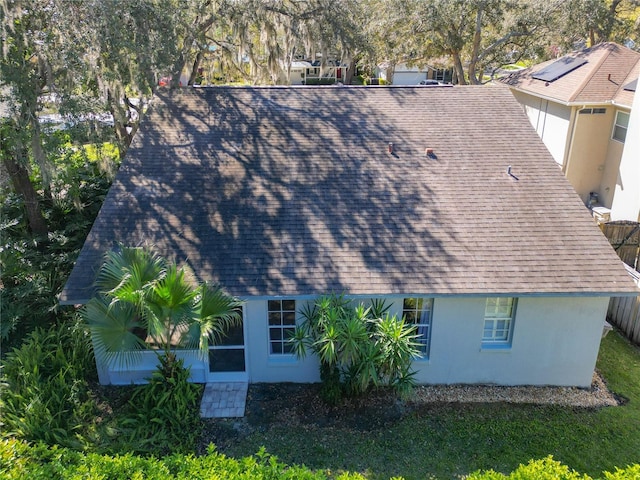 view of side of property featuring roof with shingles