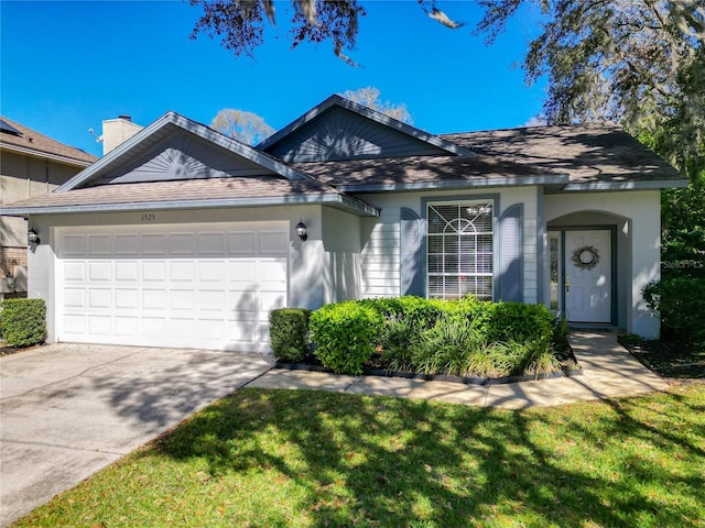 ranch-style house with a garage, driveway, and a front lawn