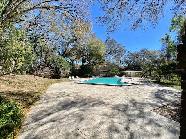 outdoor pool featuring a patio, an outdoor structure, and fence