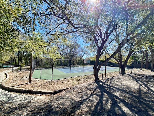 view of basketball court featuring a tennis court and fence