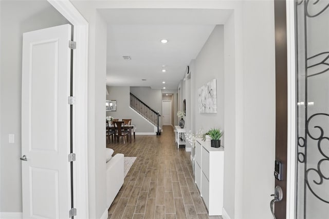 corridor with recessed lighting, light wood-type flooring, stairs, and baseboards